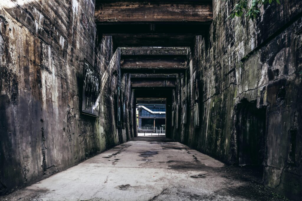 Explore the textured decay of an abandoned urban passageway, revealing industrial history.