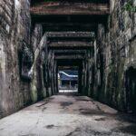 Explore the textured decay of an abandoned urban passageway, revealing industrial history.