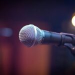 Dynamic microphone on stand with blurred stage lights in background.