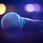 An artistic close-up of a microphone with blurred bokeh lighting, perfect for music themes.