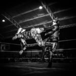 Intense Lucha Libre wrestling match showcasing strength and agility under dramatic lighting.