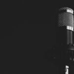 Close-up view of a studio microphone against a dark background, emphasizing audio technology.