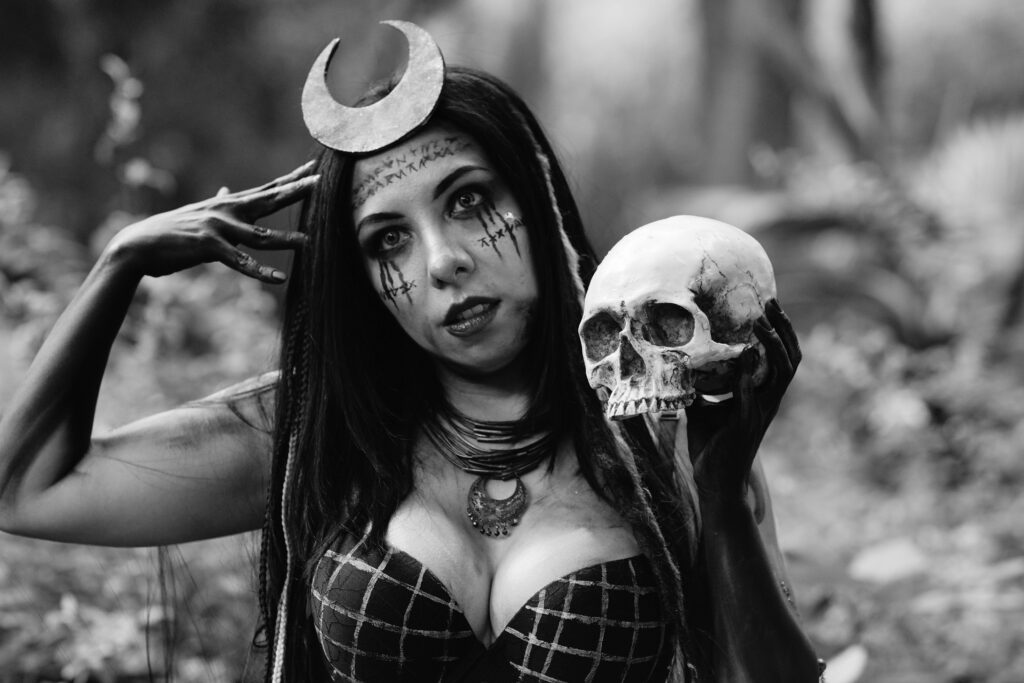 Gothic theme with woman holding a skull, set in a mystical forest.