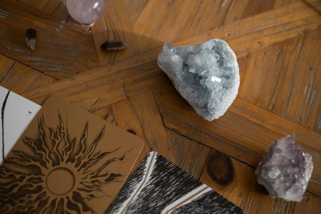 Close-up of raw crystals and tarot cards on a wooden surface, creating a mystical atmosphere.