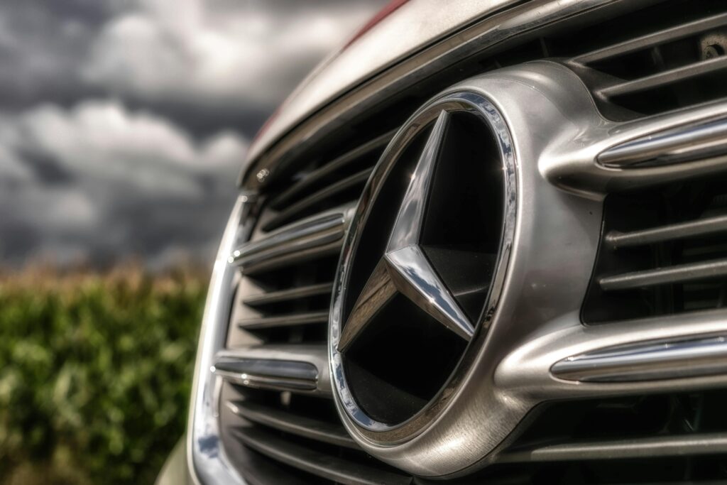 A striking close-up of a shiny Mercedes-Benz car emblem and grille, showcasing luxury.