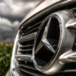 A striking close-up of a shiny Mercedes-Benz car emblem and grille, showcasing luxury.