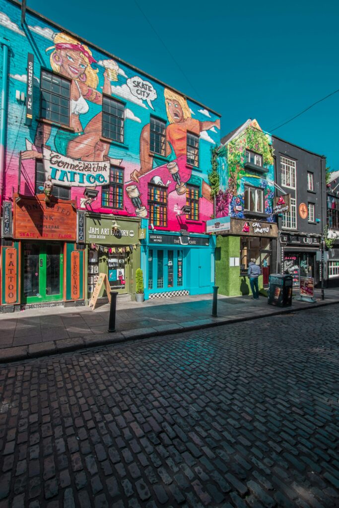 Vibrant street art and shops in a lively Dublin city street.